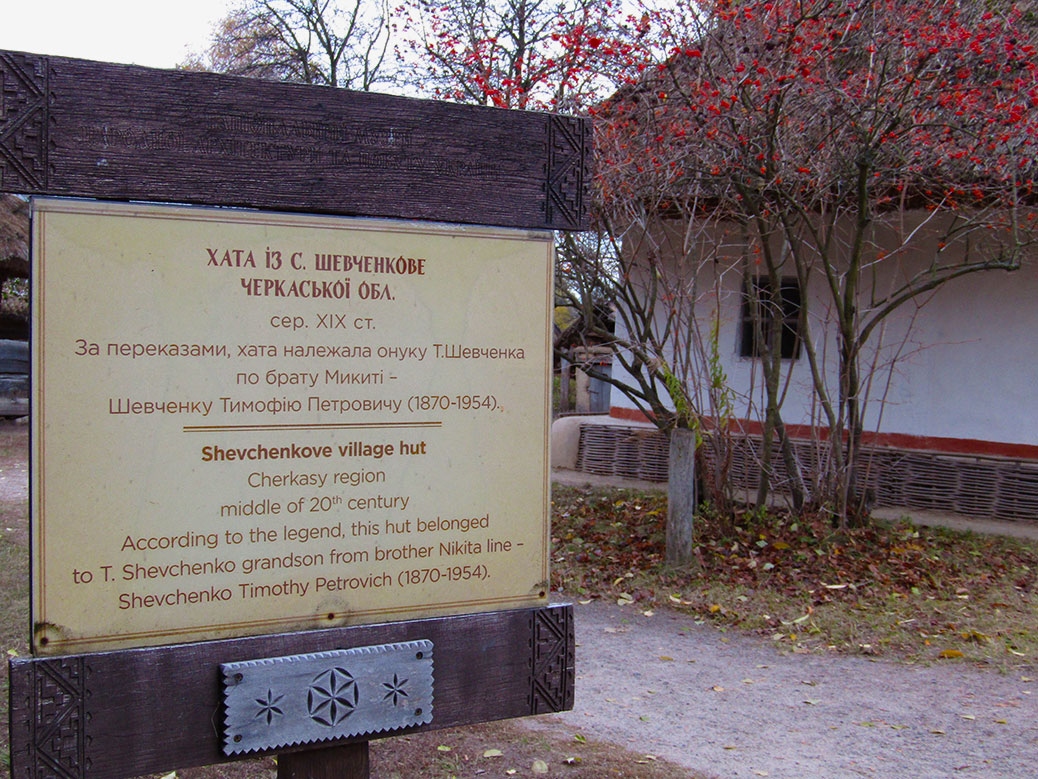 A sign explaining the origins of the home. The home and a kalyna tree are in the background.