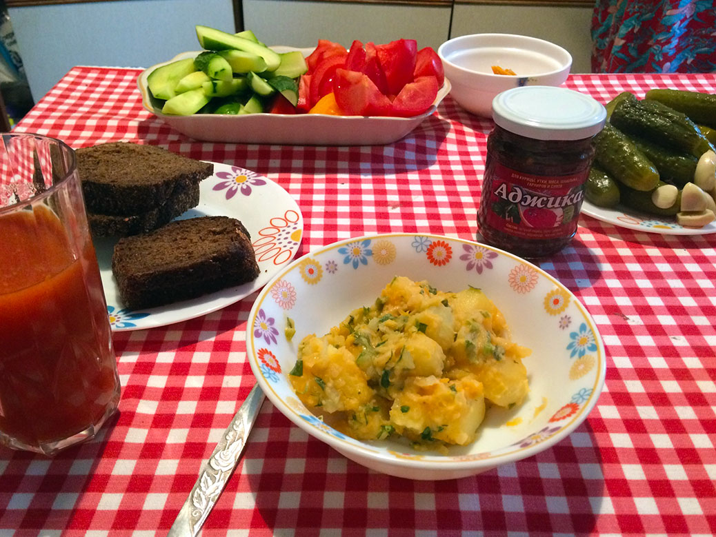 Herbed potatoes with pumpernickel bread and homemade pickles. The small jar has “adjika,” which is a spicy sauce.