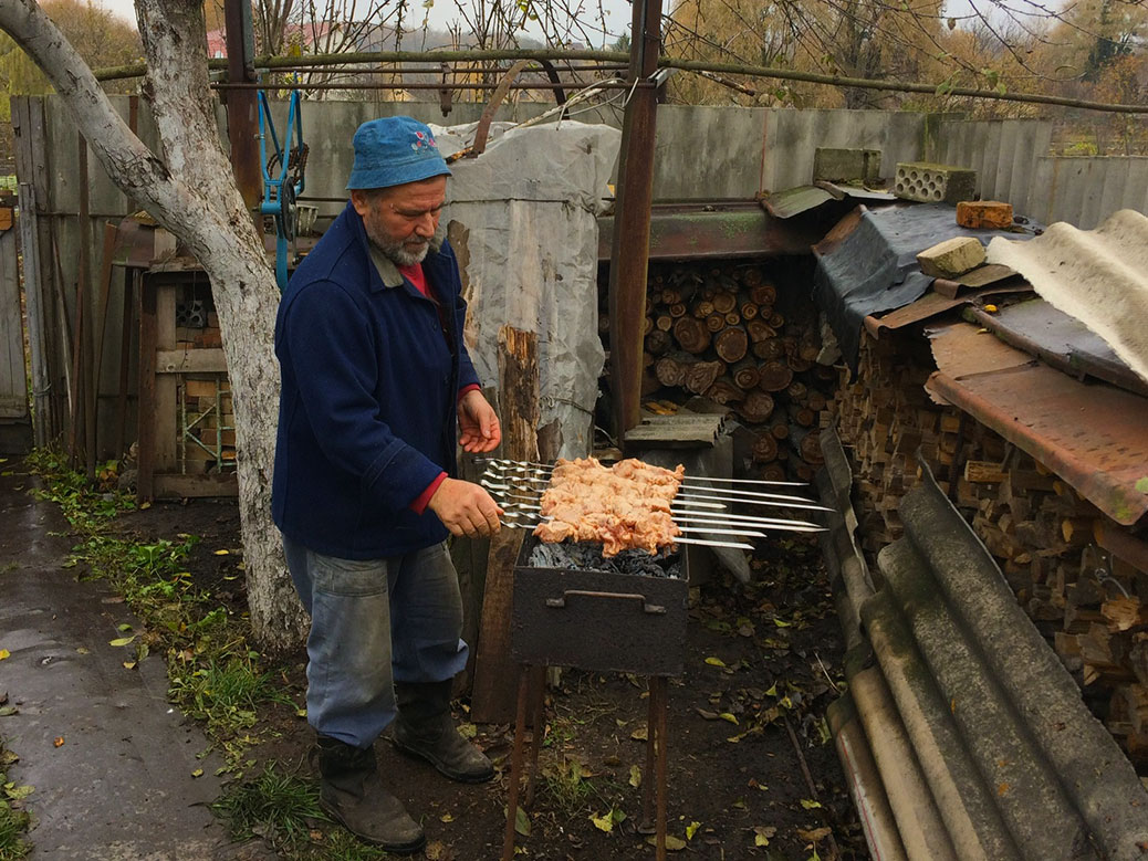 My uncle grilling some pork skewers.