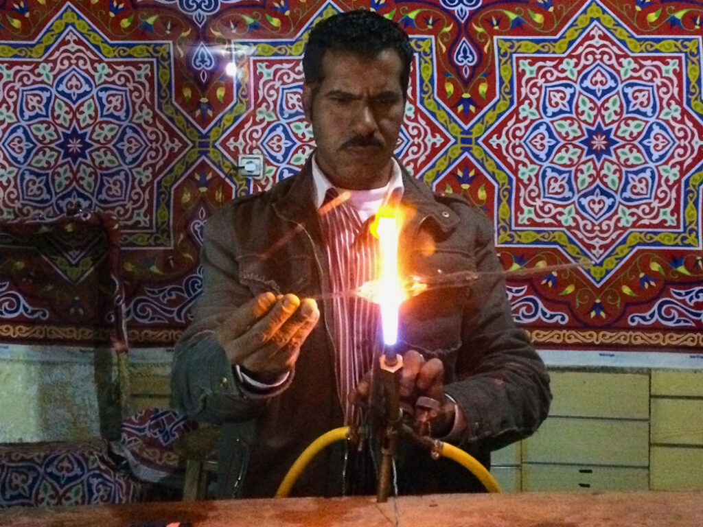 Outside the Alfayed Perfume Co. in Aswan, a man hand makes the perfume bottles used in the store.