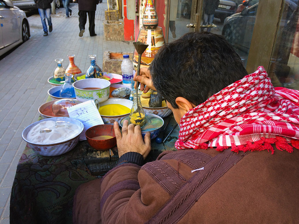 A sand artist shows off his skills on an Amman side street.